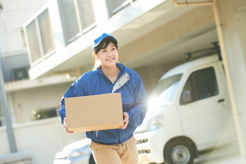走りながら小包を運ぶ女性スタッフ